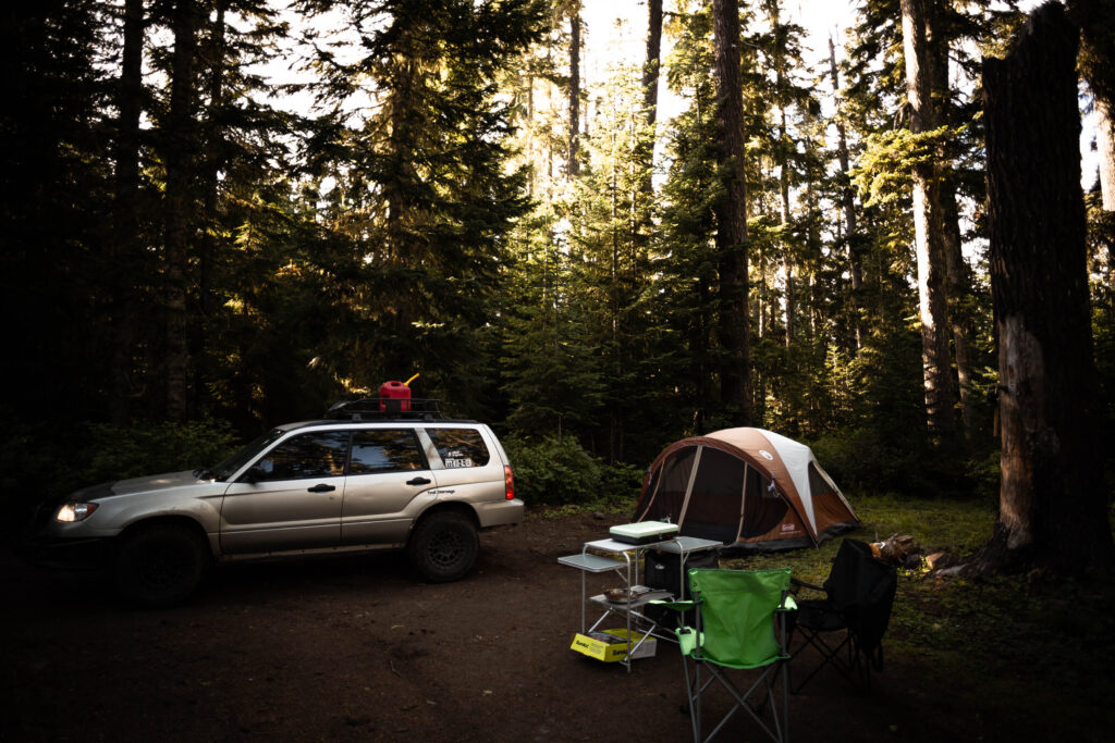 subaru forester offroad in the forest with extra gas for camping trip