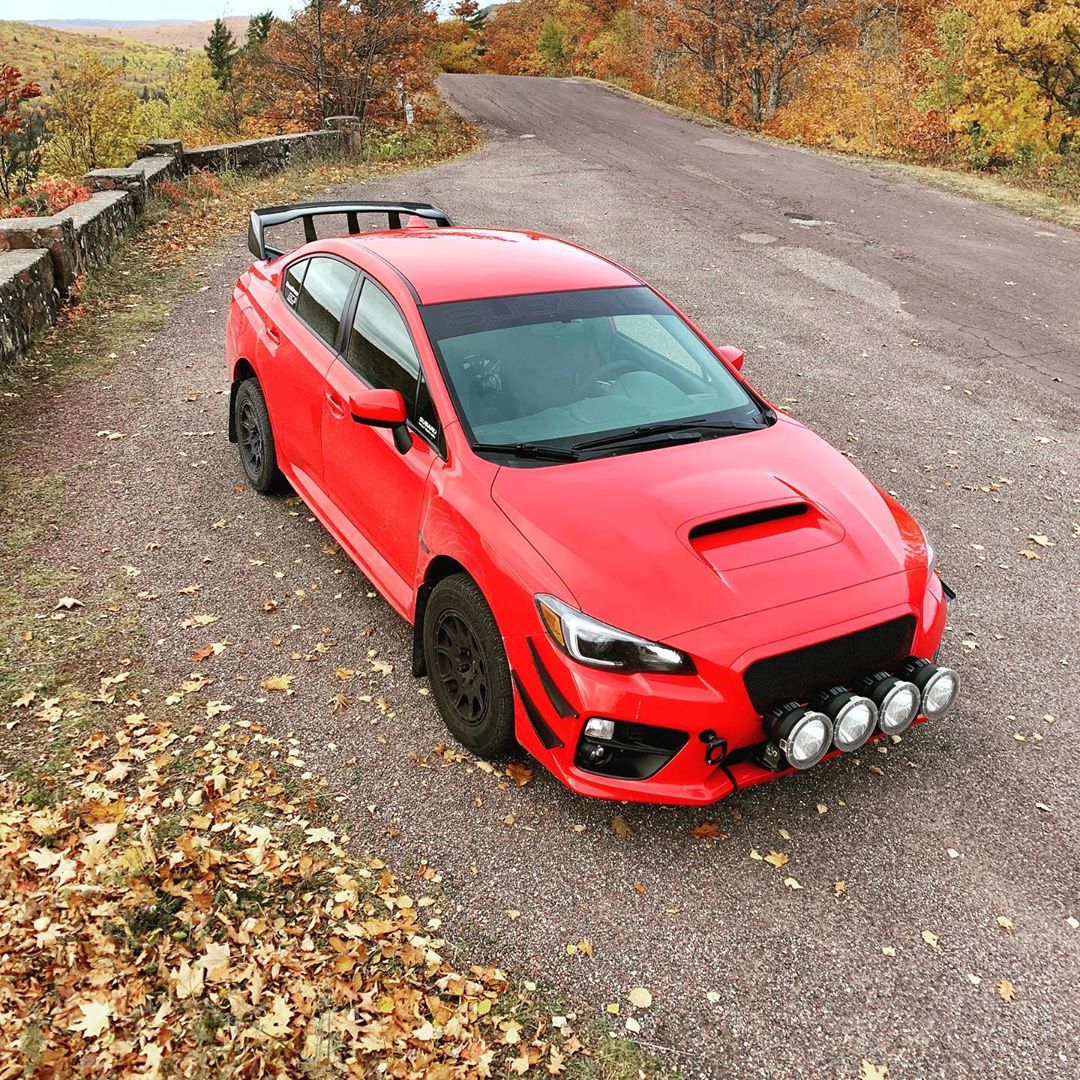 red subaru wrx on a lift kit