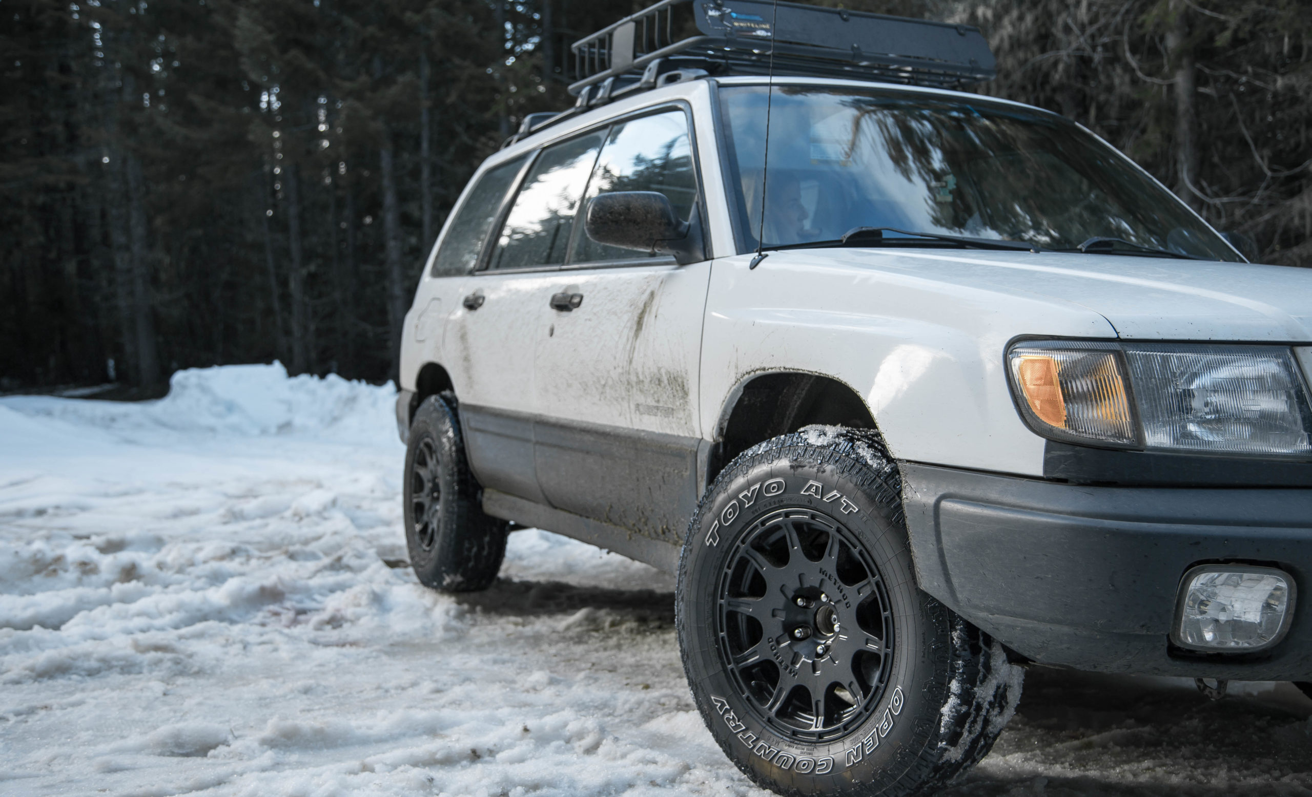 Lifted subaru forester with method mr502 wheels and toyo open country tires in the snow