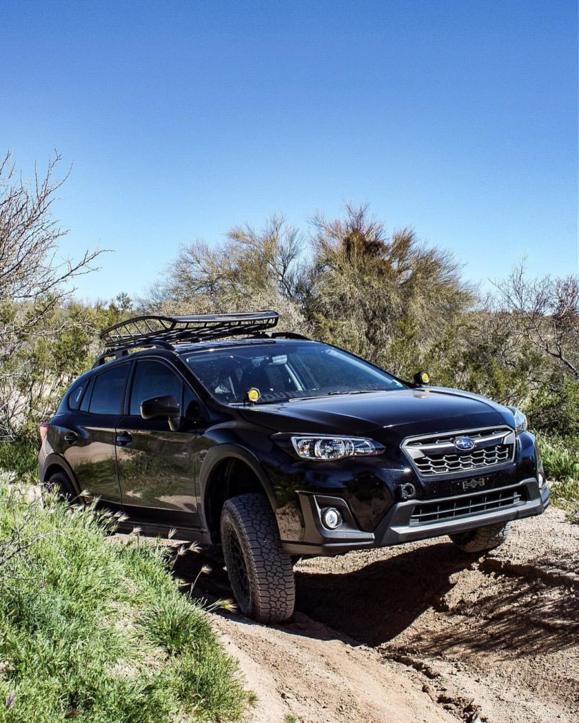 subaru crosstrek with lift kit driving on a dirt rally trail