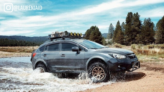 lifted crosstrek going through a river with kmc bully wheels installed and all terrain tires and kmc bully wheels