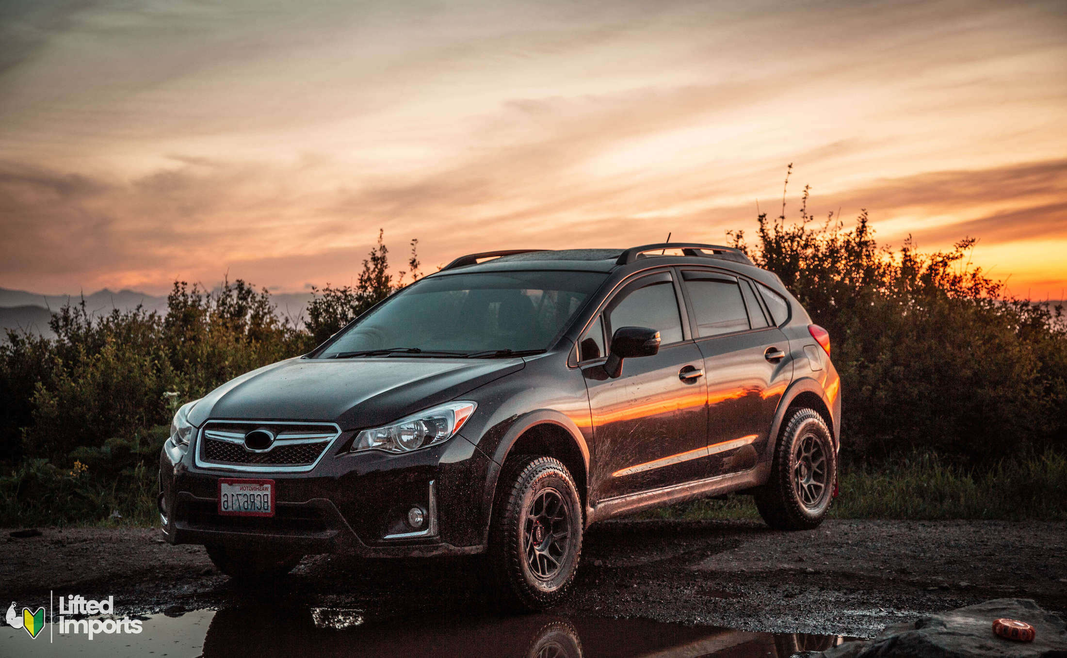 lifted subaru crosstrek with KMC bully wheels and open range tires at sunset