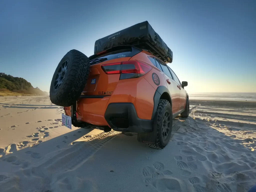 Subaru-crosstrek-lifted-in-orange-at-the-beach-with-all-terrain-tires