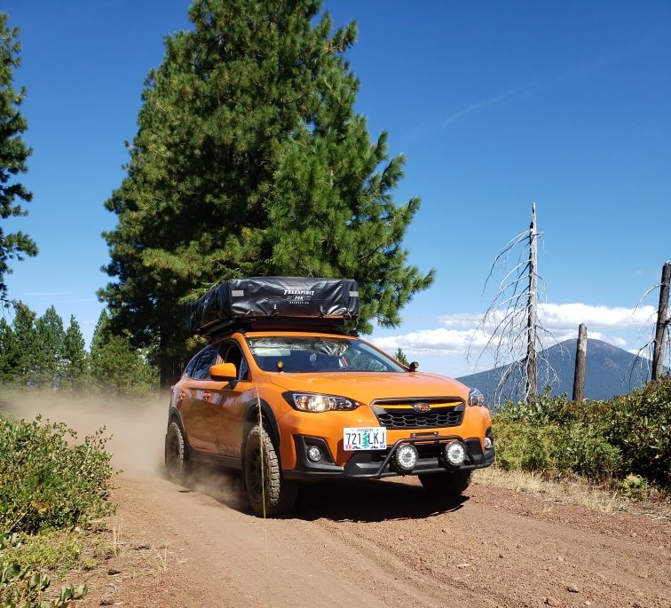 lifted Subaru crosstrek in orange on dirt road