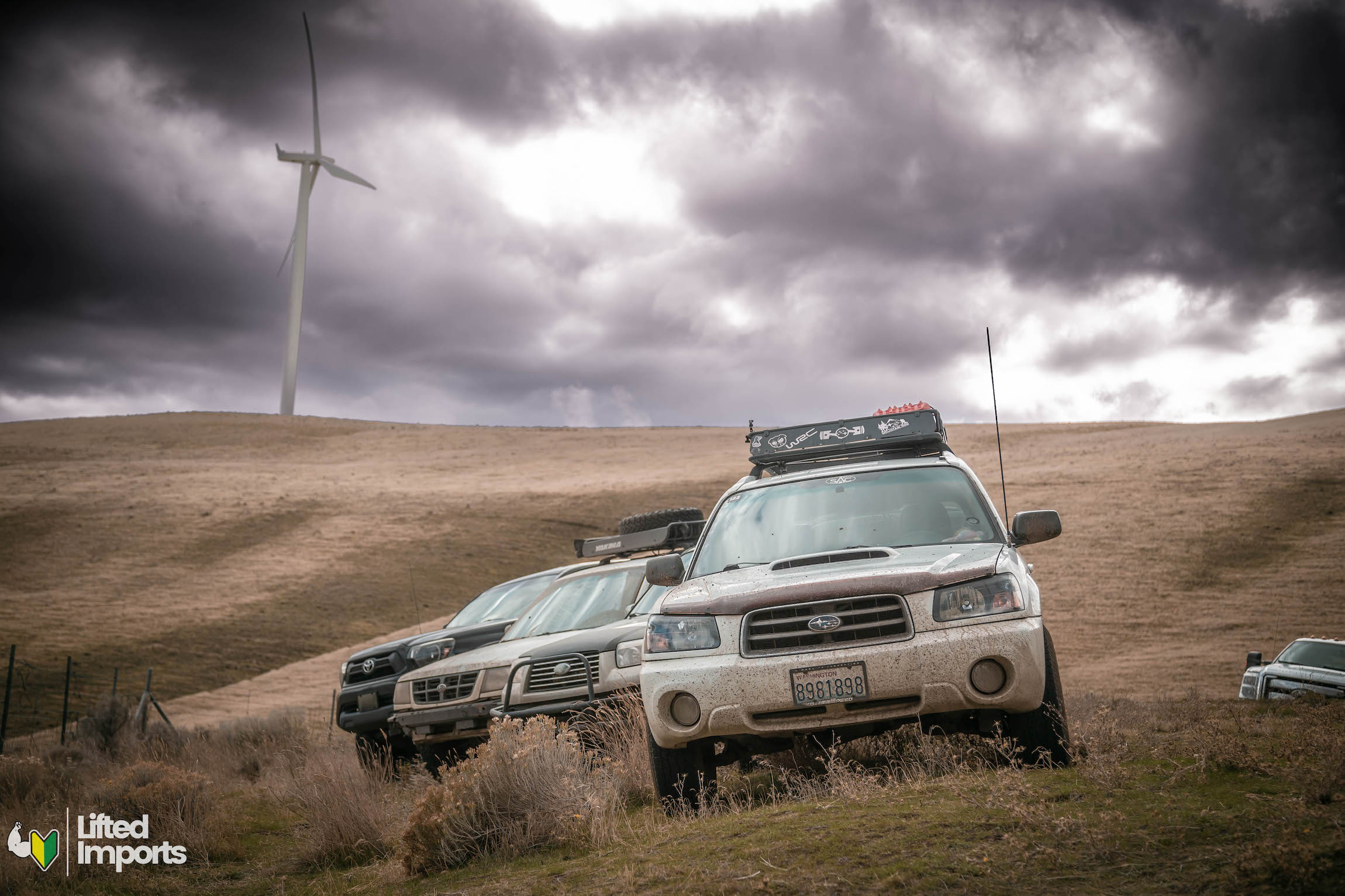 lifted subaru foresters parked under cloudy skies off-road