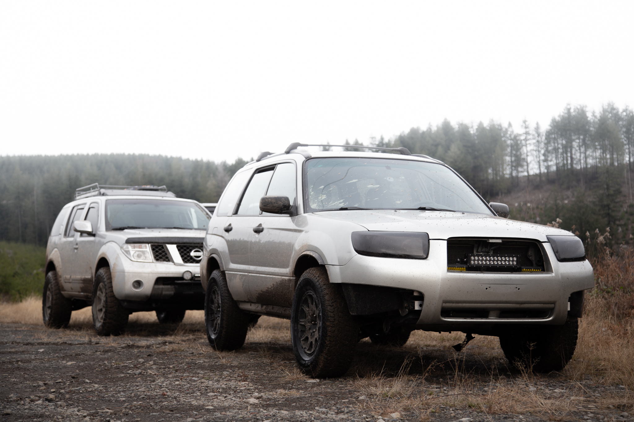 lifted 2006 subaru forester in the forest with a lifted pathfinder