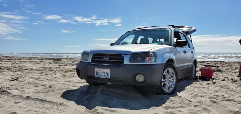 lowered subaru forester on the beach driving in the sand