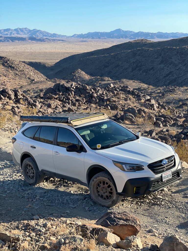 lifted subaru outback XT with roof rack in the desert