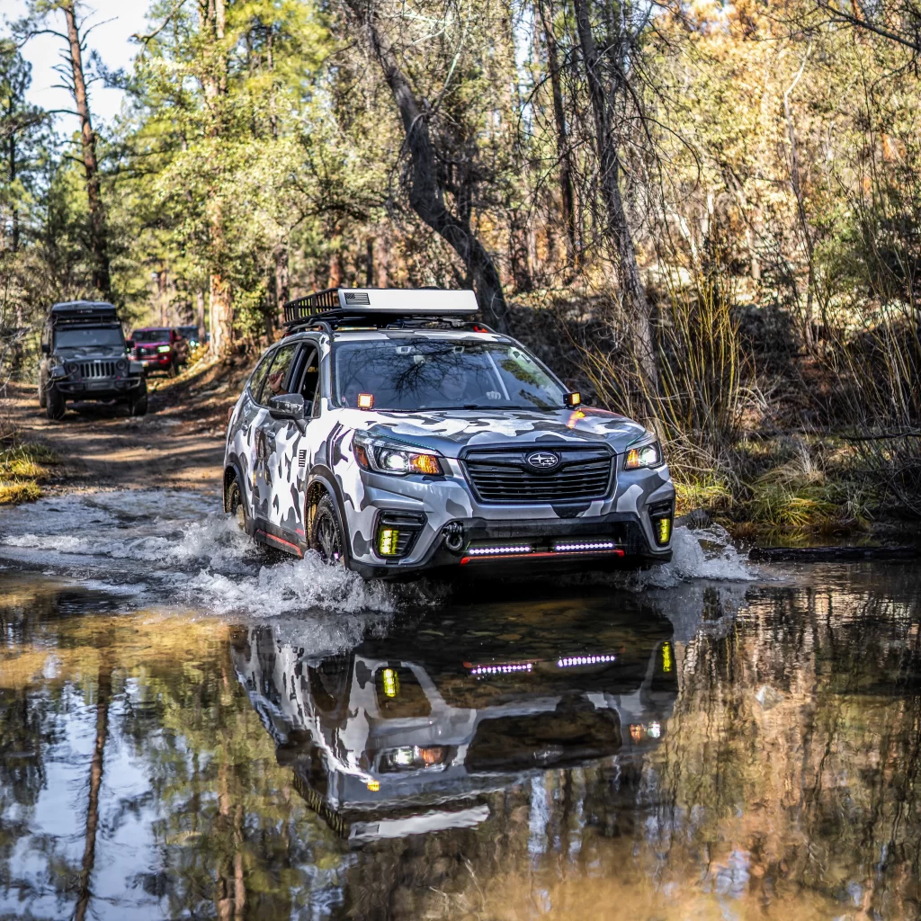 lifted 2020 forester sport with offroad tires going through a creek