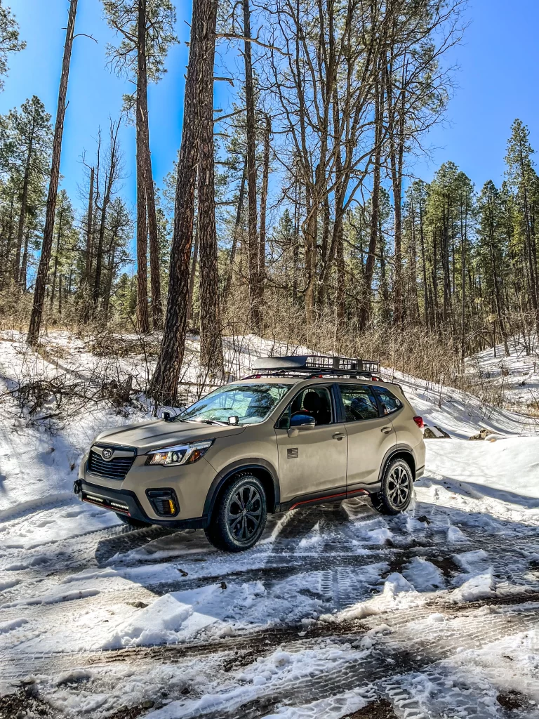 lifted 2020 subaru forester offroad in snow with lift kit and mud tires