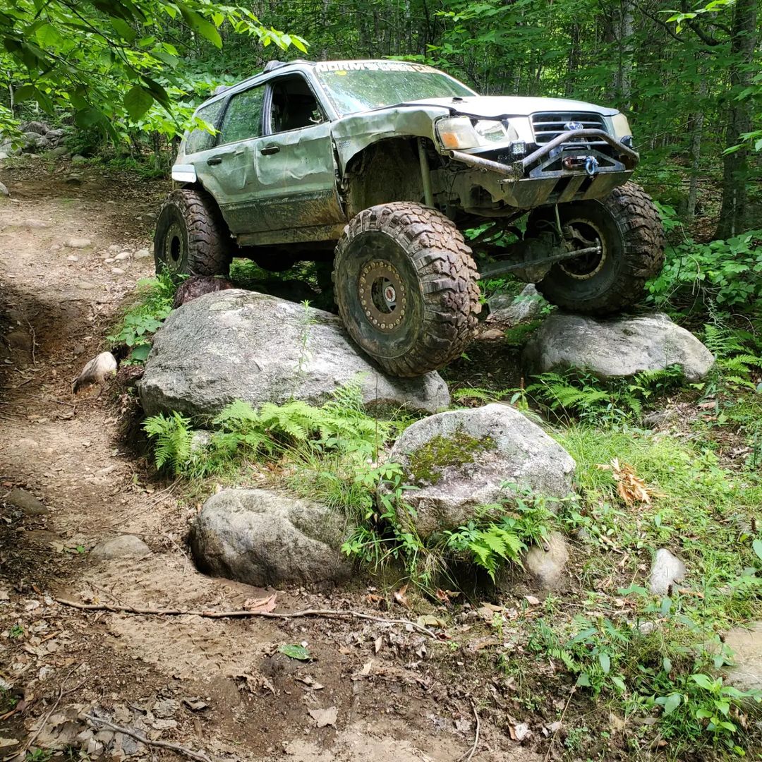 lifted subaru forester monster truck on toyota suspension in the forest on 42 inch tires