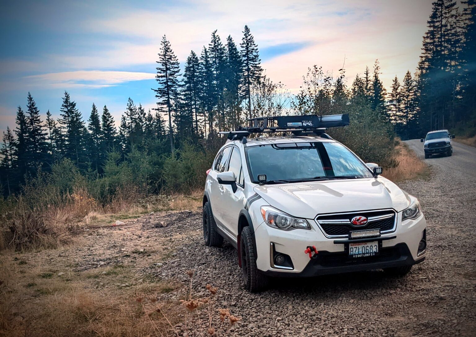 2016 subaru crosstrek lifted with offroad tires and wheels in the forest with lightbar
