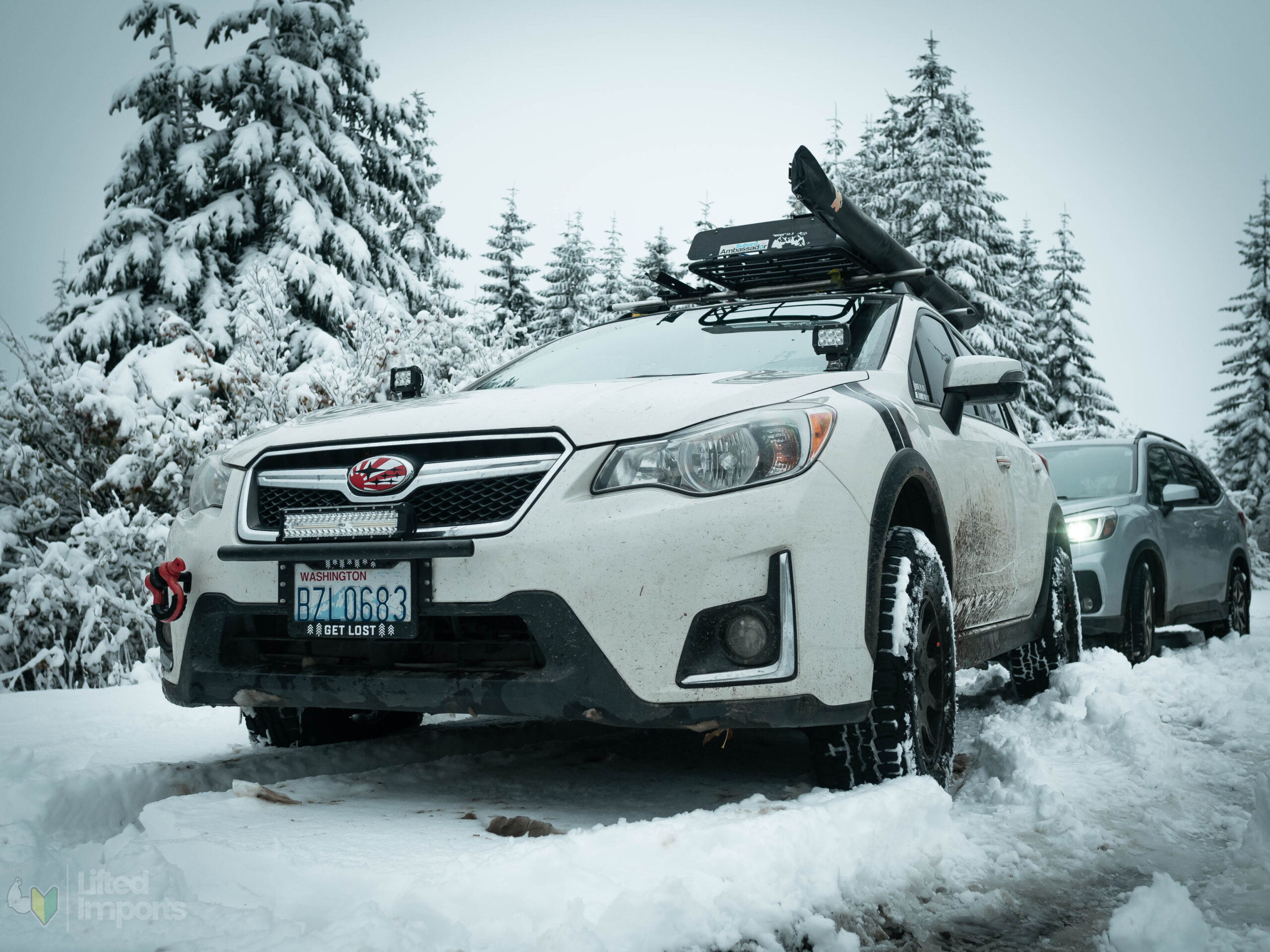 white lifted subaru crosstrek with offroad tires and method mr502 wheels in the snow front bumper