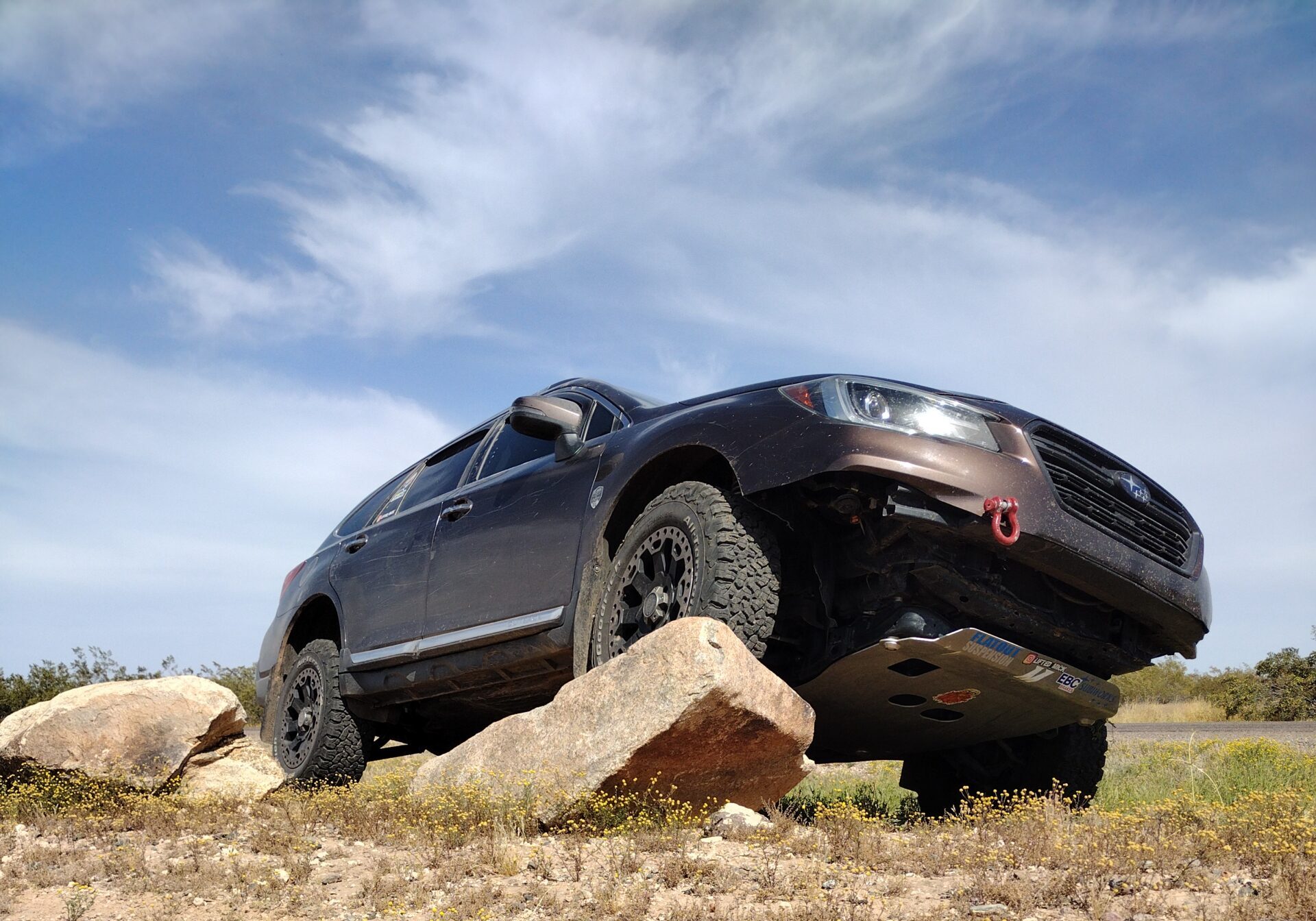 subaru outback 36R with lift kit and offroad tires on a rock