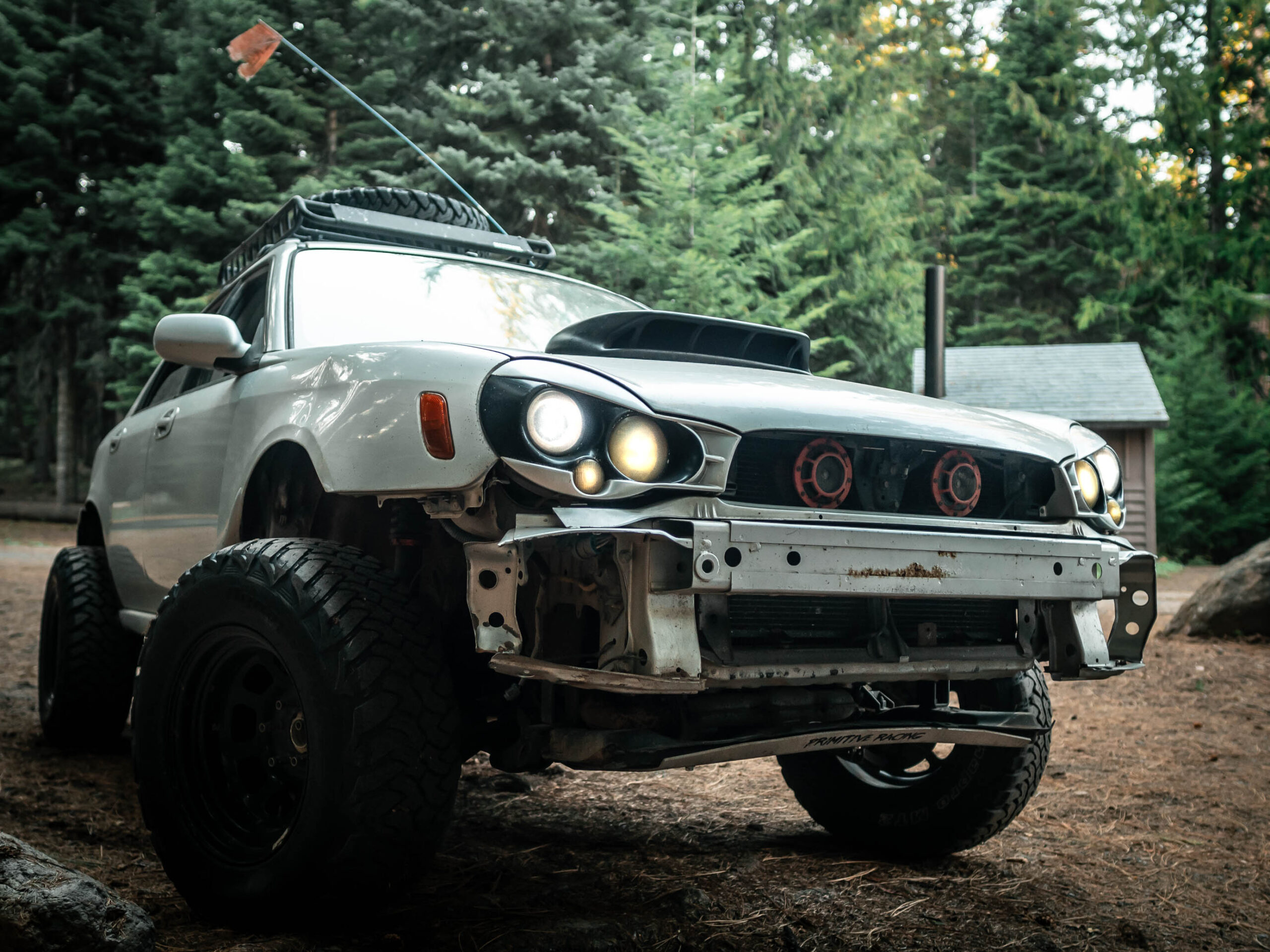 lifted subaru wrx offroad in the forest with Morette headlights