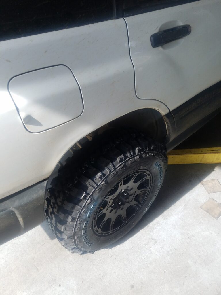 offroad tires being installed on subaru forester
