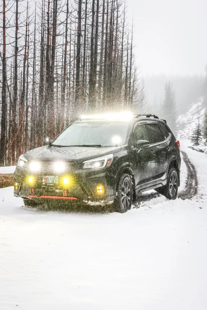 modified subaru forester with pod lights in snow