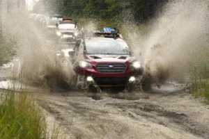 red subaru outback splashing through water with a snorkel